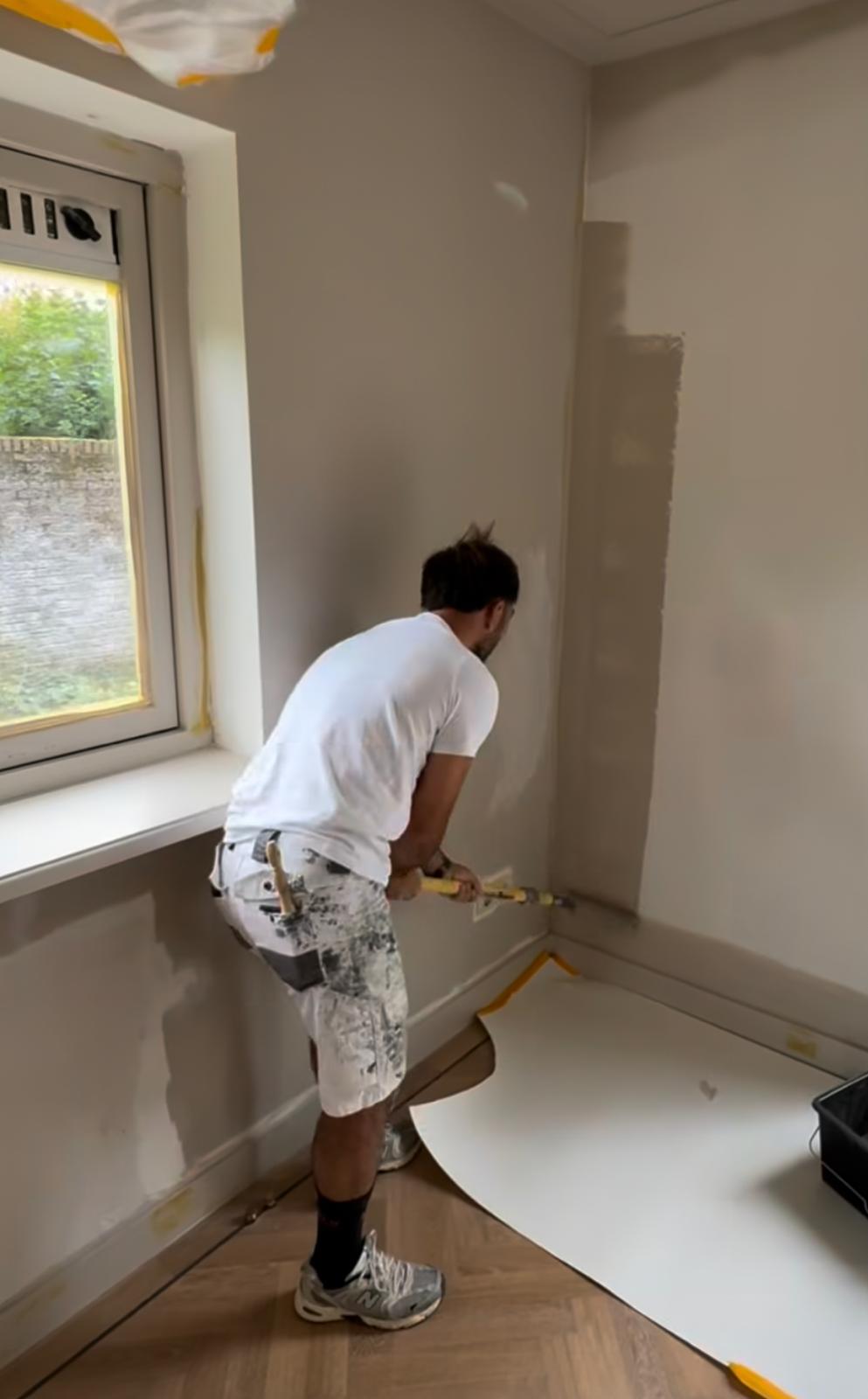 Ed snijdt strak een muur af tijdens binnenschilderwerk